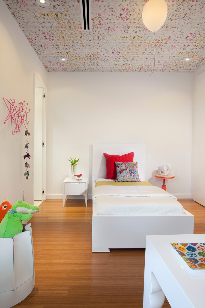 Minimalist gender-neutral medium tone wood floor kids' room photo in Miami with white walls