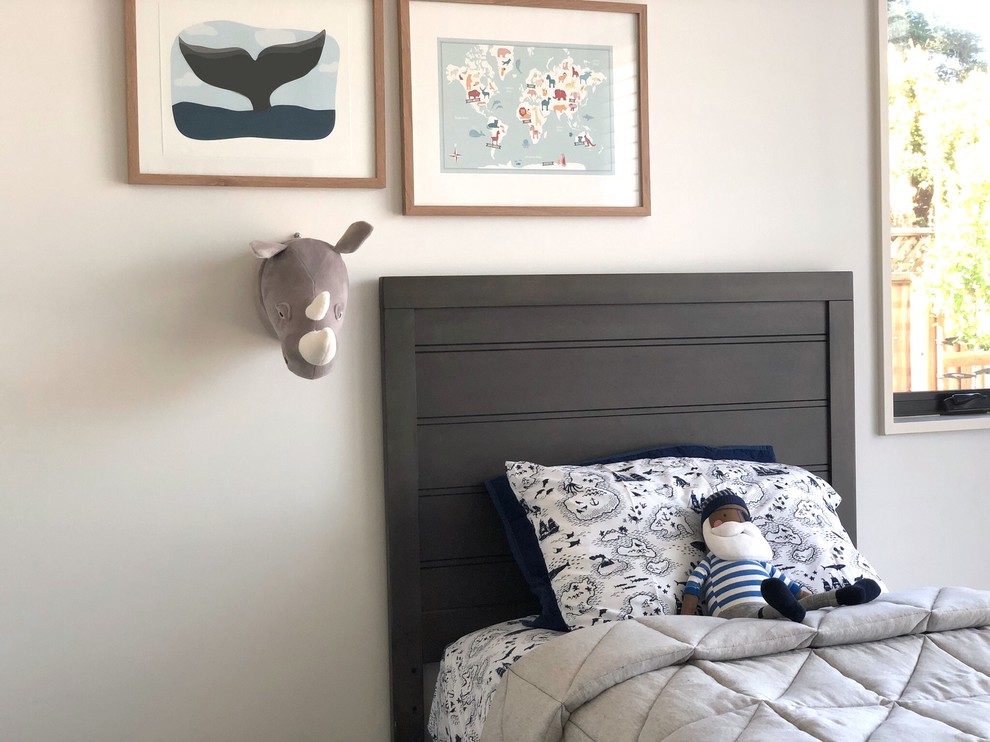 Inspiration pour une chambre d'enfant de 4 à 10 ans minimaliste de taille moyenne avec un mur blanc, un sol en bois brun et un sol marron.