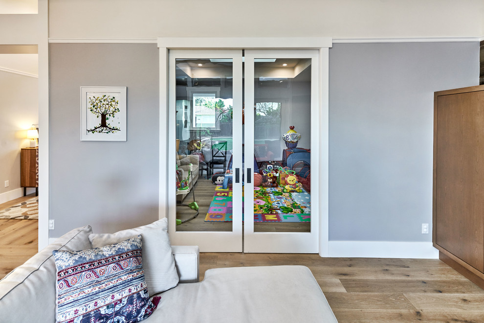 Idéer för ett mellanstort klassiskt könsneutralt småbarnsrum kombinerat med lekrum, med grå väggar och ljust trägolv