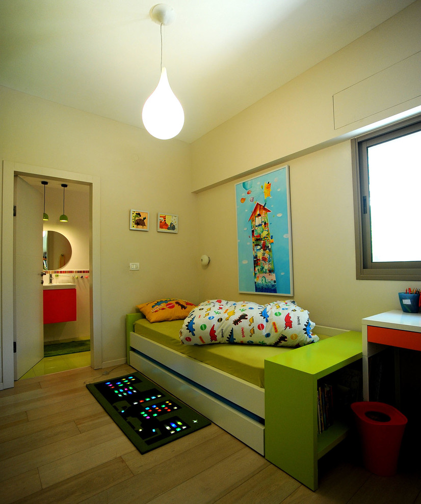 Exempel på ett mellanstort modernt pojkrum kombinerat med sovrum och för 4-10-åringar, med beige väggar, ljust trägolv och beiget golv