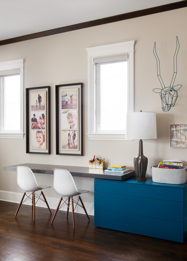 This is an example of a contemporary gender neutral kids' study space in Chicago with beige walls, dark hardwood flooring and brown floors.