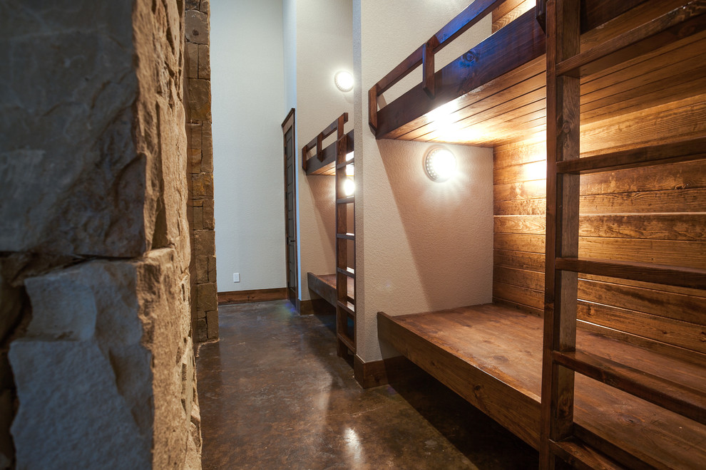 Imagen de dormitorio infantil rural extra grande con paredes beige y suelo de cemento