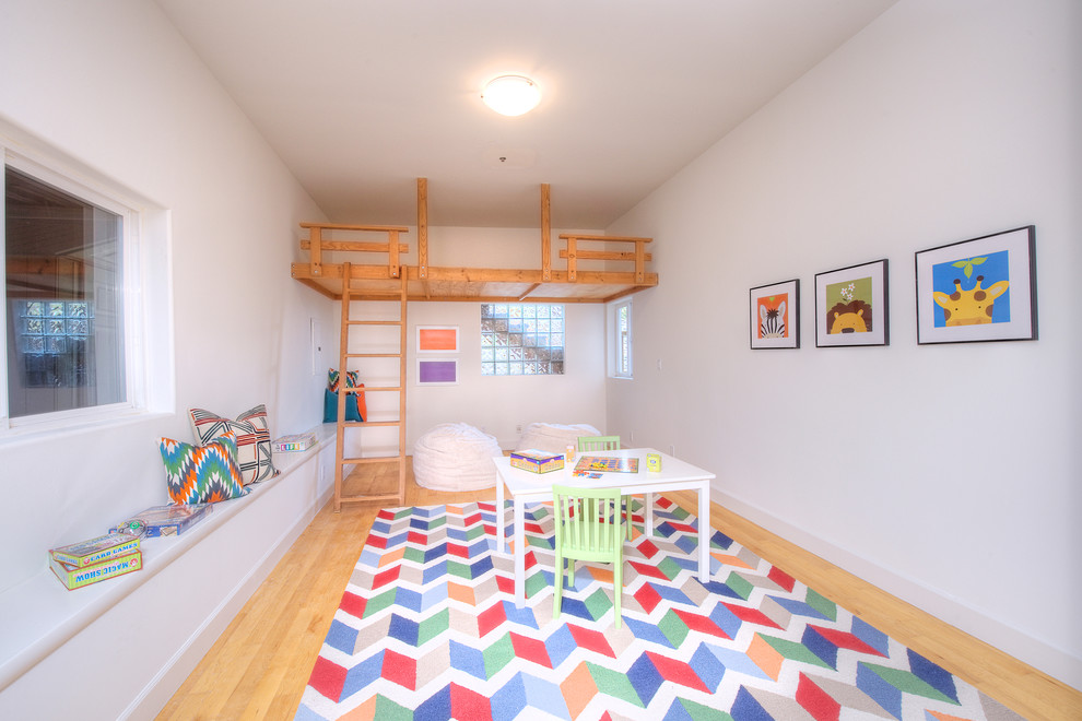 Example of a mid-sized trendy gender-neutral light wood floor kids' room design in San Francisco with white walls