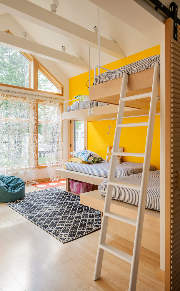 Idée de décoration pour une chambre d'enfant design avec un mur jaune et un lit superposé.