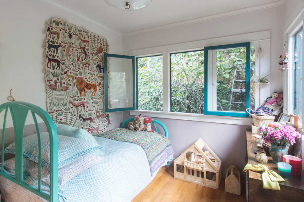 Cette image montre une chambre de fille bohème avec un mur gris et un sol en bois brun.
