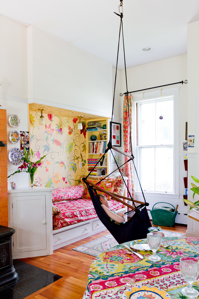 Diseño de dormitorio infantil de 4 a 10 años bohemio con suelo de madera en tonos medios y paredes multicolor