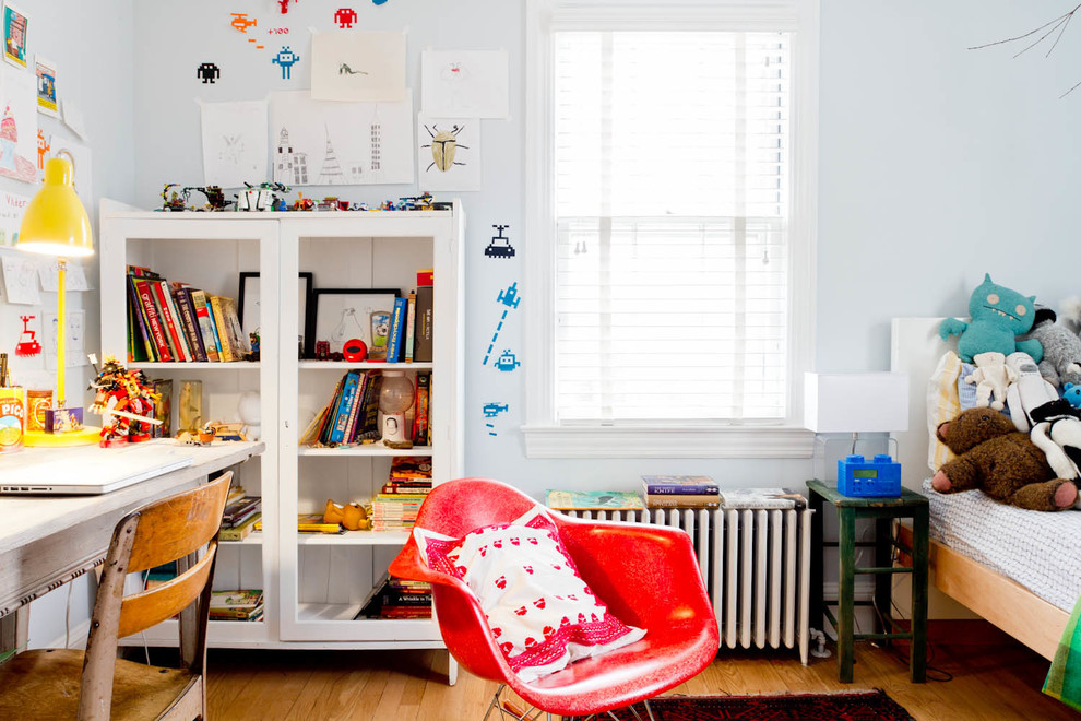 Idée de décoration pour une chambre de garçon de 4 à 10 ans bohème avec un bureau, un mur bleu et un sol en bois brun.