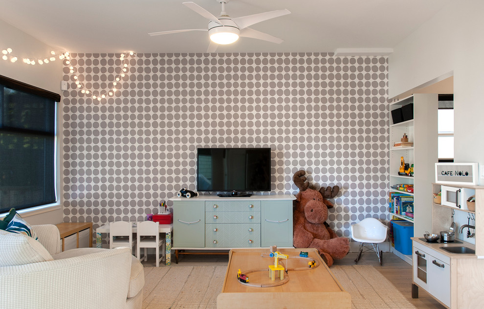 Modern inredning av ett pojkrum kombinerat med lekrum, med flerfärgade väggar och ljust trägolv
