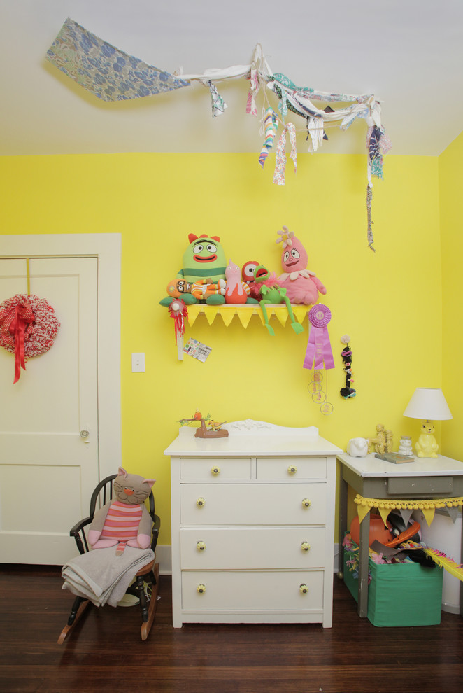 Exempel på ett klassiskt könsneutralt småbarnsrum, med gula väggar och mörkt trägolv