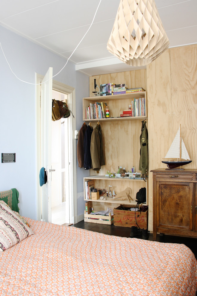 Inredning av ett skandinaviskt könsneutralt tonårsrum kombinerat med sovrum, med blå väggar och mörkt trägolv