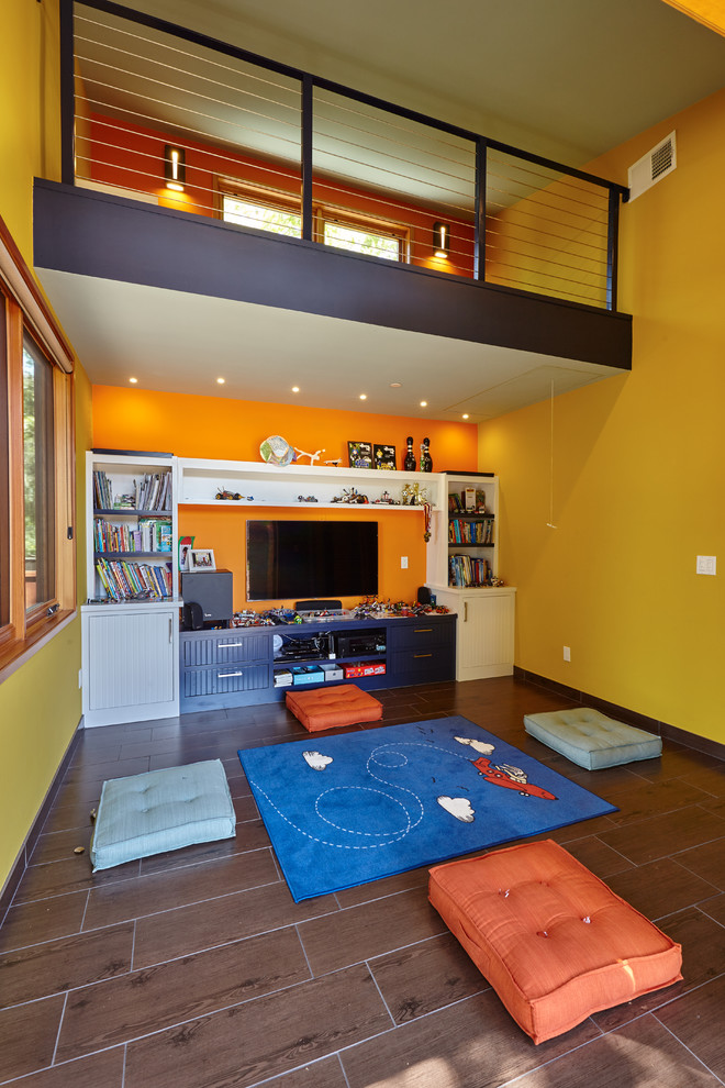 Foto på ett mellanstort funkis pojkrum kombinerat med lekrum och för 4-10-åringar, med flerfärgade väggar, laminatgolv och brunt golv