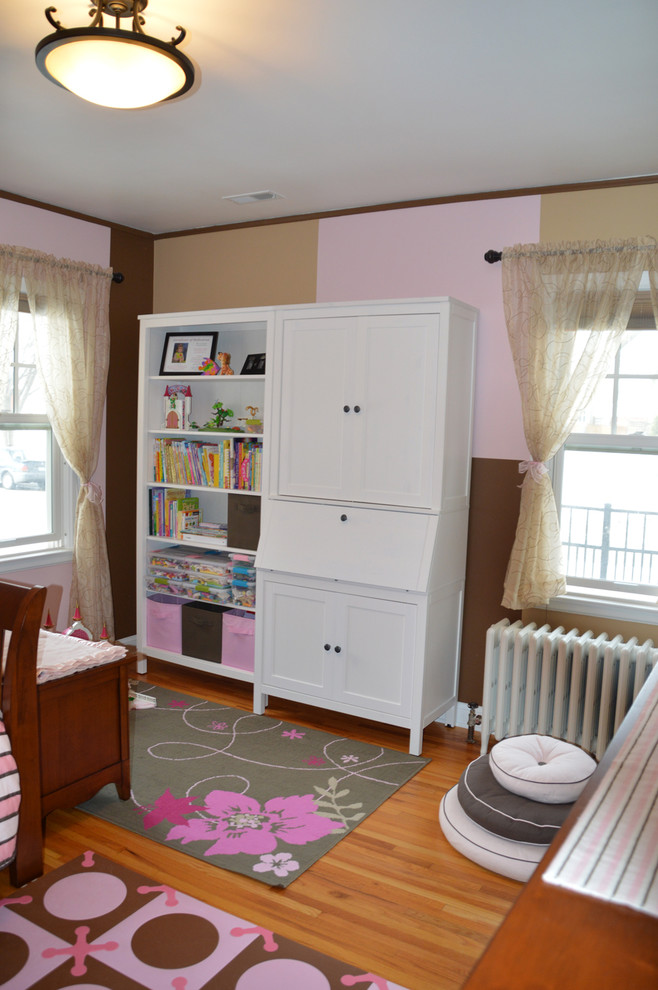Inspiration for a timeless girl medium tone wood floor childrens' room remodel in Minneapolis with pink walls