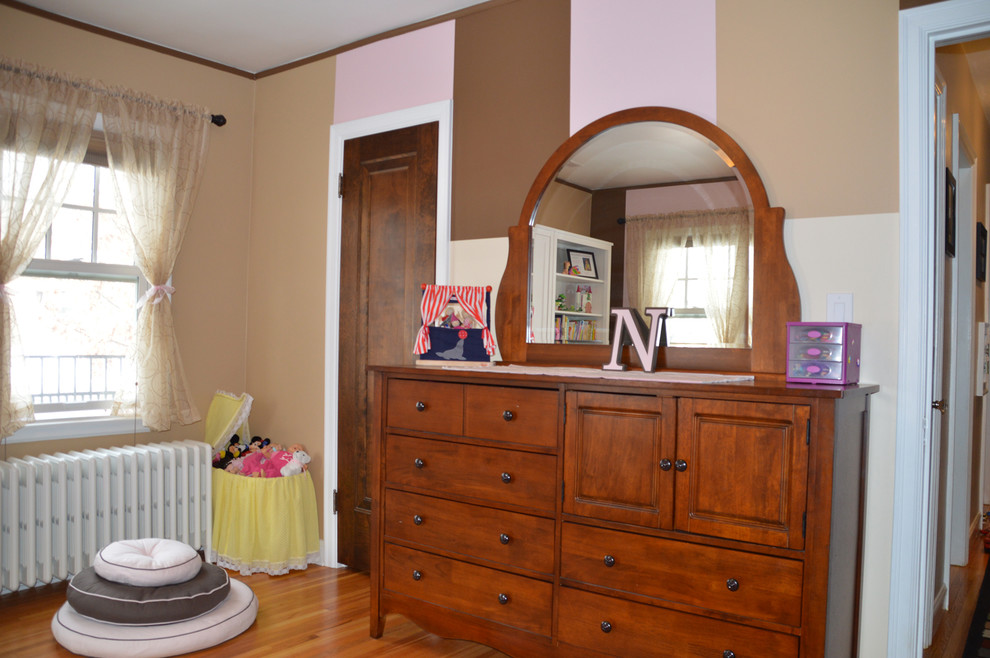 Immagine di una cameretta da bambina da 4 a 10 anni tradizionale con pareti rosa e pavimento in legno massello medio