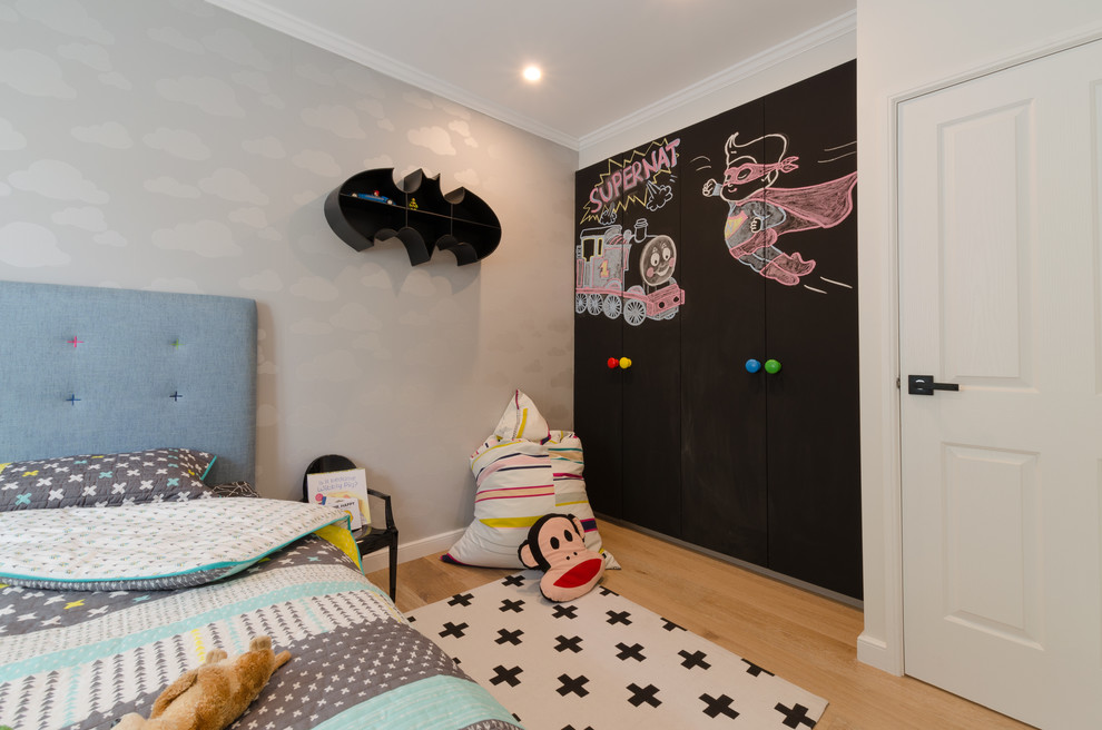 Idee per una cameretta per bambini contemporanea di medie dimensioni con pareti bianche e parquet chiaro