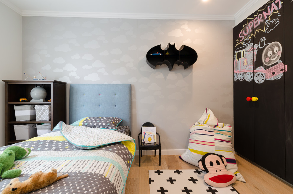 Diseño de dormitorio infantil actual de tamaño medio con paredes blancas y suelo de madera clara
