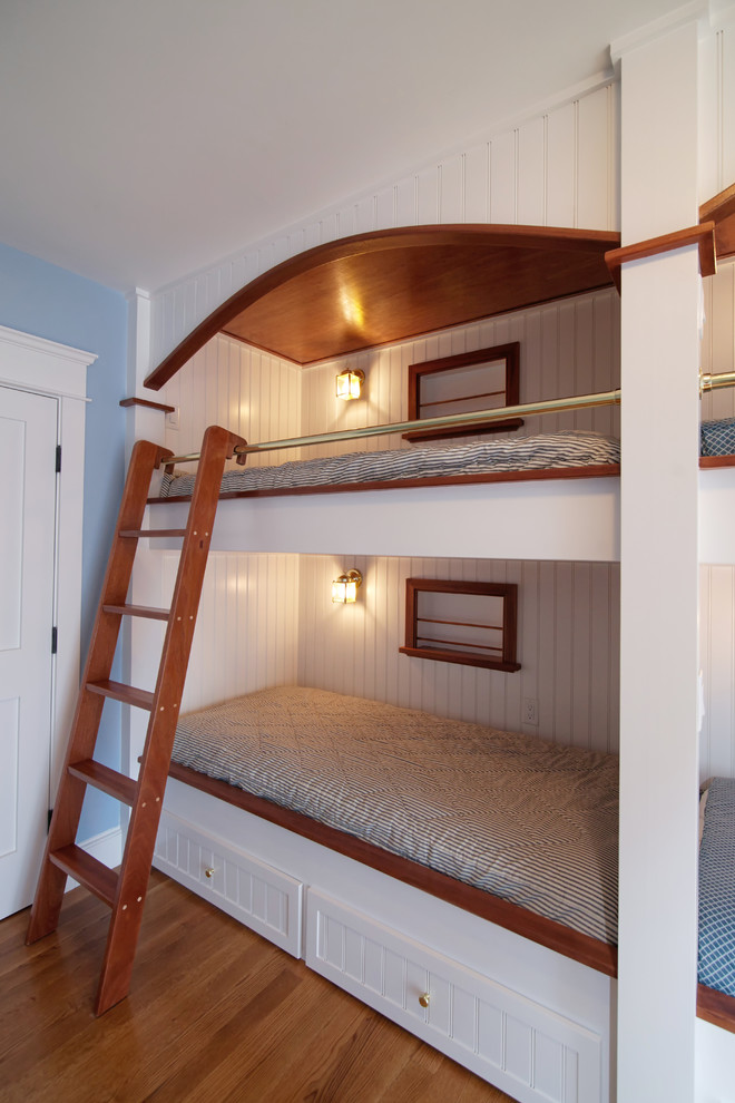 Réalisation d'une chambre d'enfant de 4 à 10 ans marine de taille moyenne avec un mur bleu, parquet foncé et un sol marron.