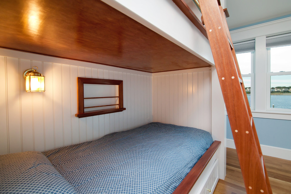Idéer för mellanstora maritima könsneutrala barnrum kombinerat med sovrum och för 4-10-åringar, med blå väggar, mörkt trägolv och brunt golv