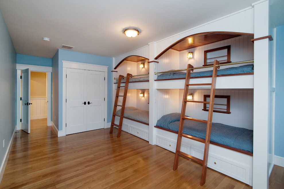 Diseño de dormitorio infantil de 4 a 10 años costero de tamaño medio con paredes azules, suelo de madera oscura y suelo marrón