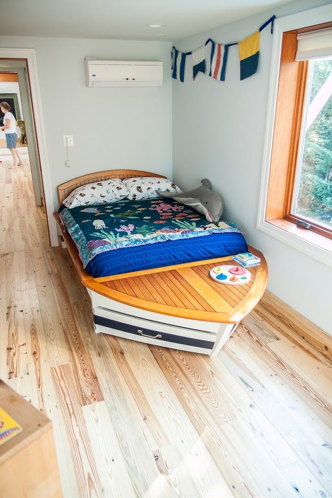 Ejemplo de dormitorio infantil de 4 a 10 años de estilo americano de tamaño medio con paredes azules y suelo de madera clara
