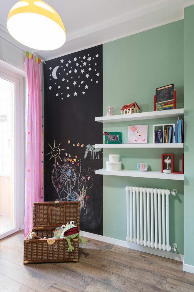 Ispirazione per una cameretta per bambini da 1 a 3 anni moderna con pareti verdi e parquet chiaro