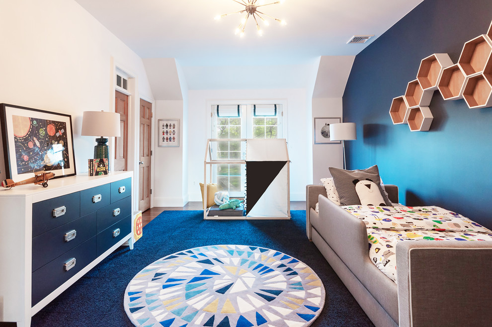 Esempio di una grande cameretta per bambini da 1 a 3 anni tradizionale con pareti blu, pavimento in legno massello medio e pavimento marrone