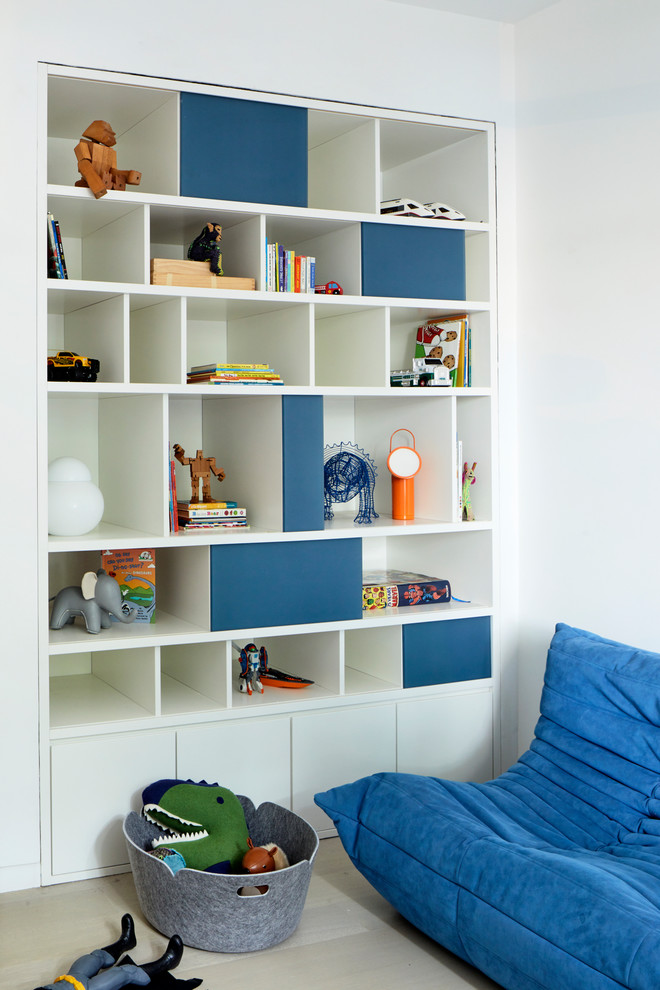 This is an example of a contemporary playroom for boys in New York with white walls and beige floors.