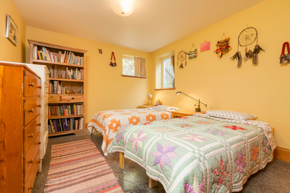 Bild på ett mellanstort amerikanskt könsneutralt barnrum kombinerat med sovrum och för 4-10-åringar, med gula väggar och betonggolv