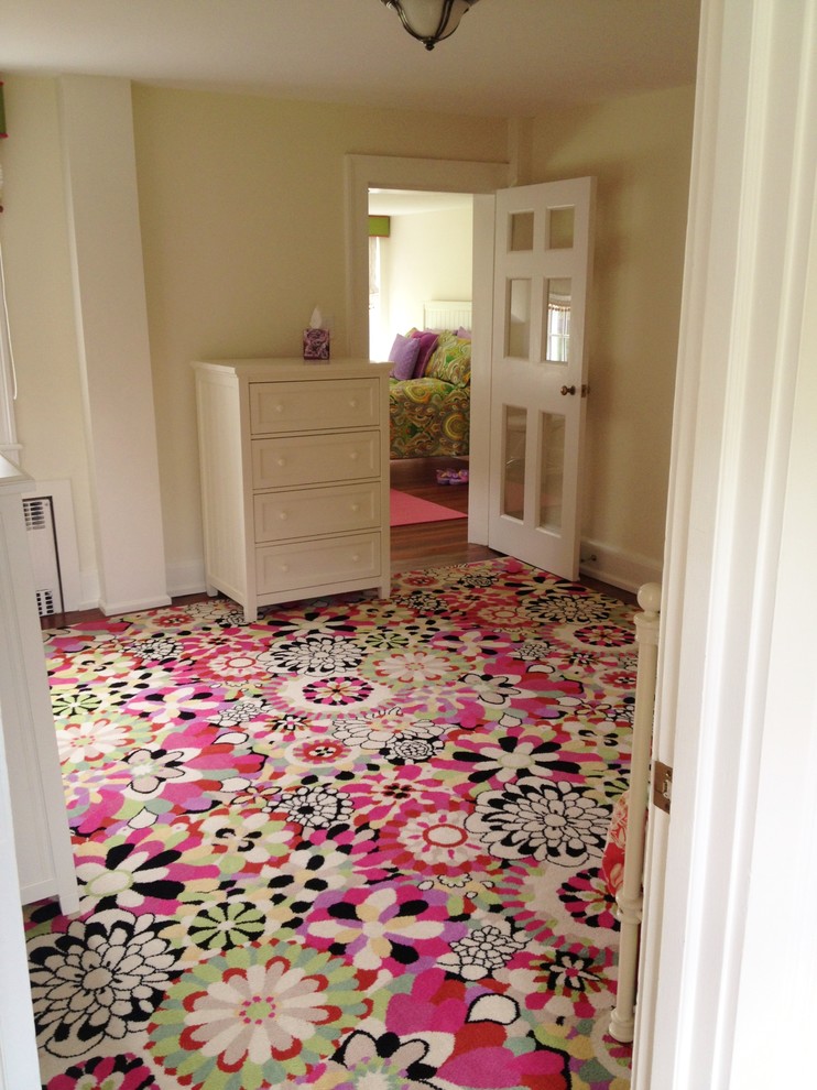 Expansive classic children’s room for girls in New York with beige walls and carpet.