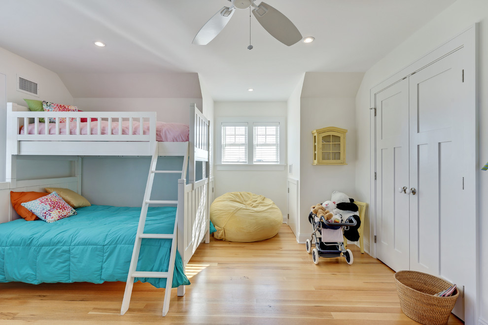 Ejemplo de dormitorio infantil costero grande con paredes blancas y suelo de madera clara
