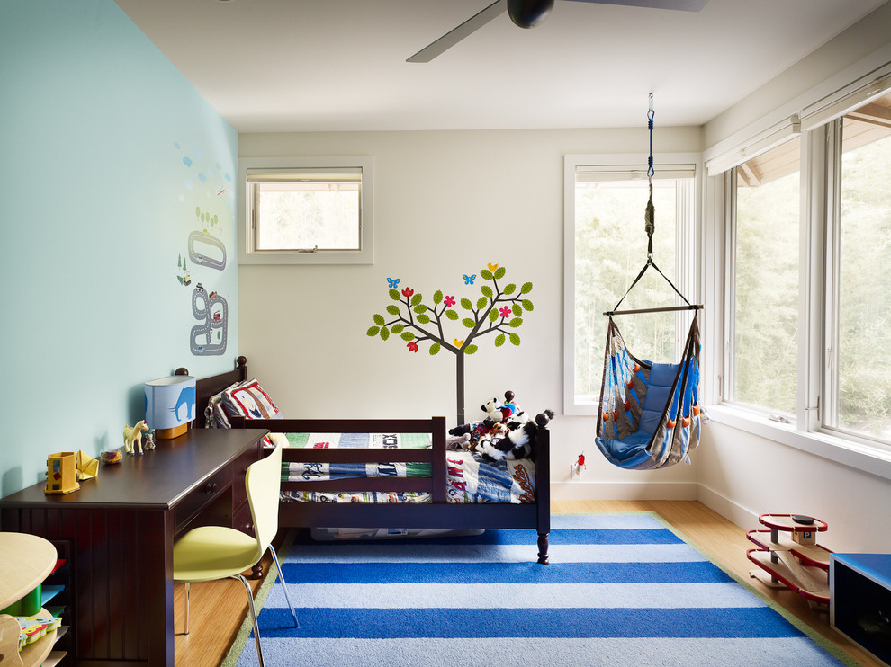 Inspiration pour une chambre d'enfant de 1 à 3 ans traditionnelle avec un sol en bois brun et un mur multicolore.