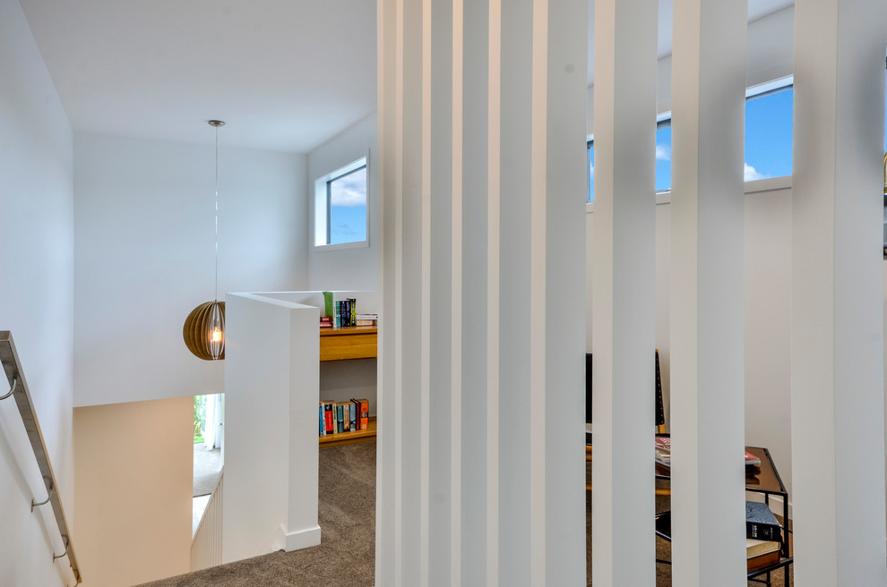Ejemplo de habitación infantil unisex minimalista grande con escritorio, paredes blancas, moqueta y suelo beige