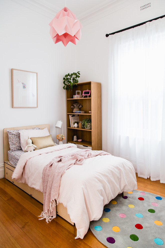 Idee per una cameretta per bambini da 4 a 10 anni contemporanea con pareti bianche, pavimento in legno massello medio e pavimento marrone