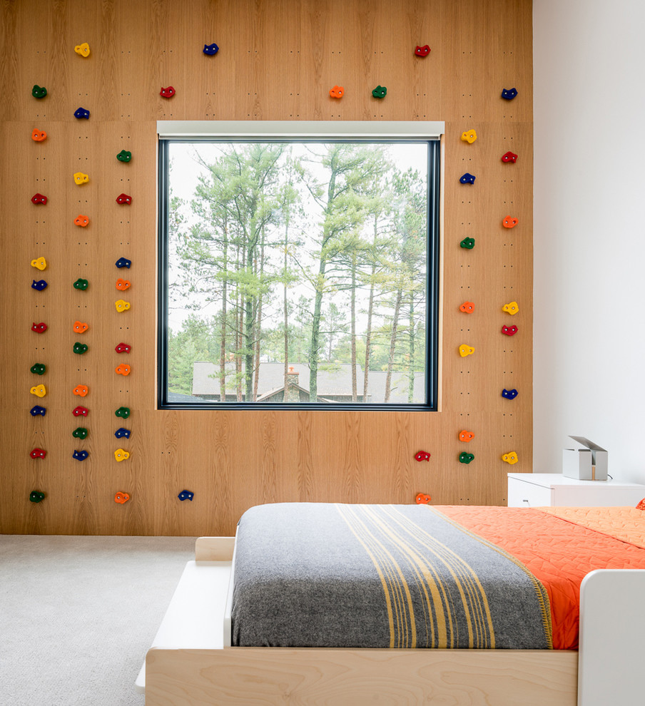 На фото: нейтральная детская в стиле модернизм с ковровым покрытием, серым полом и спальным местом