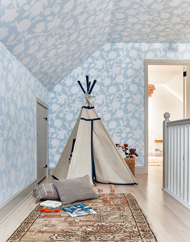 This is an example of a coastal kids' bedroom in New York with blue walls, light hardwood flooring and beige floors.