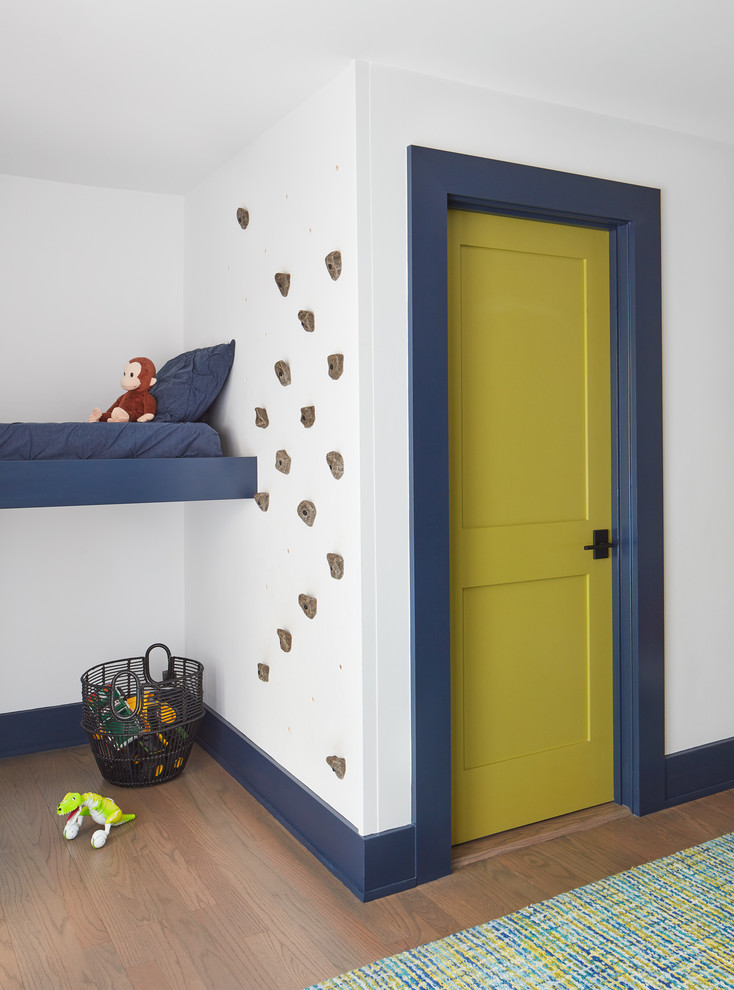 Ispirazione per una cameretta per bambini da 4 a 10 anni stile marino con pareti bianche e pavimento in legno massello medio