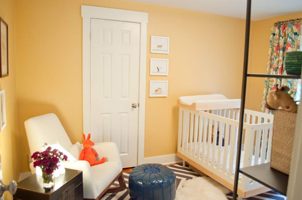 Idée de décoration pour une chambre d'enfant de 1 à 3 ans tradition de taille moyenne avec un mur orange, un sol en bois brun et un sol marron.