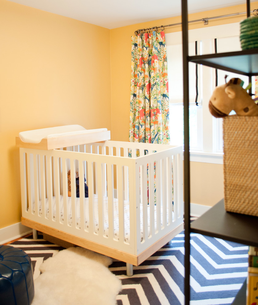 Inspiration pour une chambre de bébé traditionnelle de taille moyenne avec un mur orange, un sol en bois brun et un sol marron.