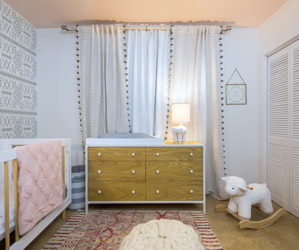 This is an example of a medium sized contemporary toddler’s room for girls in Miami with white walls, porcelain flooring and orange floors.