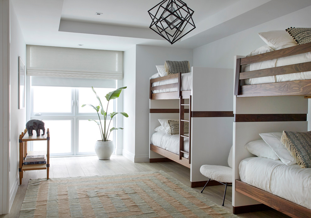 Aménagement d'une chambre d'enfant bord de mer avec un mur blanc, un sol beige et un lit superposé.