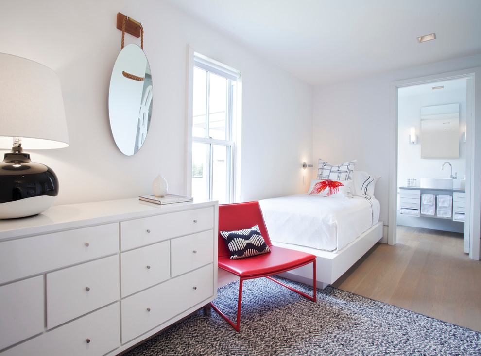 This is an example of a large nautical gender neutral kids' bedroom in Boston with white walls and medium hardwood flooring.