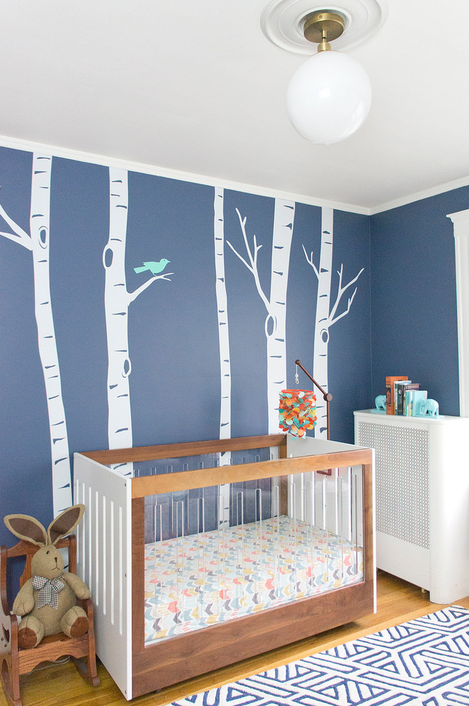 Imagen de dormitorio infantil de 1 a 3 años ecléctico de tamaño medio con paredes azules y suelo de madera en tonos medios