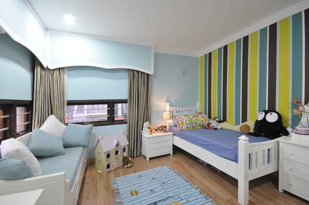 Esempio di una cameretta per bambini da 1 a 3 anni chic con pareti blu e pavimento in legno massello medio