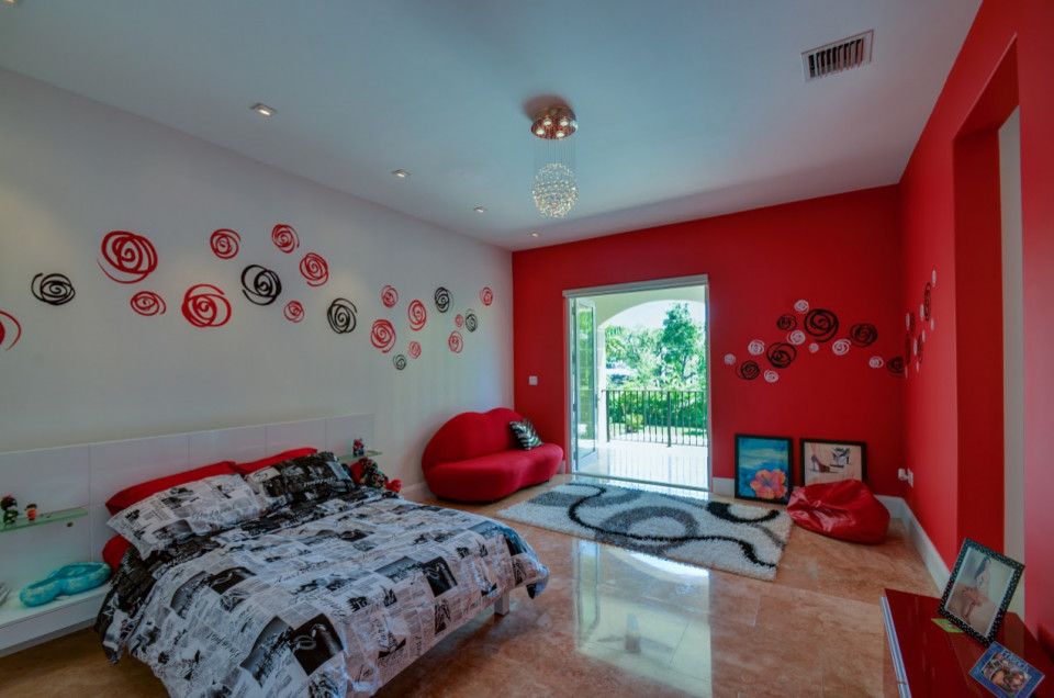 Cette image montre une chambre d'enfant ethnique avec un mur rouge, un sol en marbre et un sol beige.