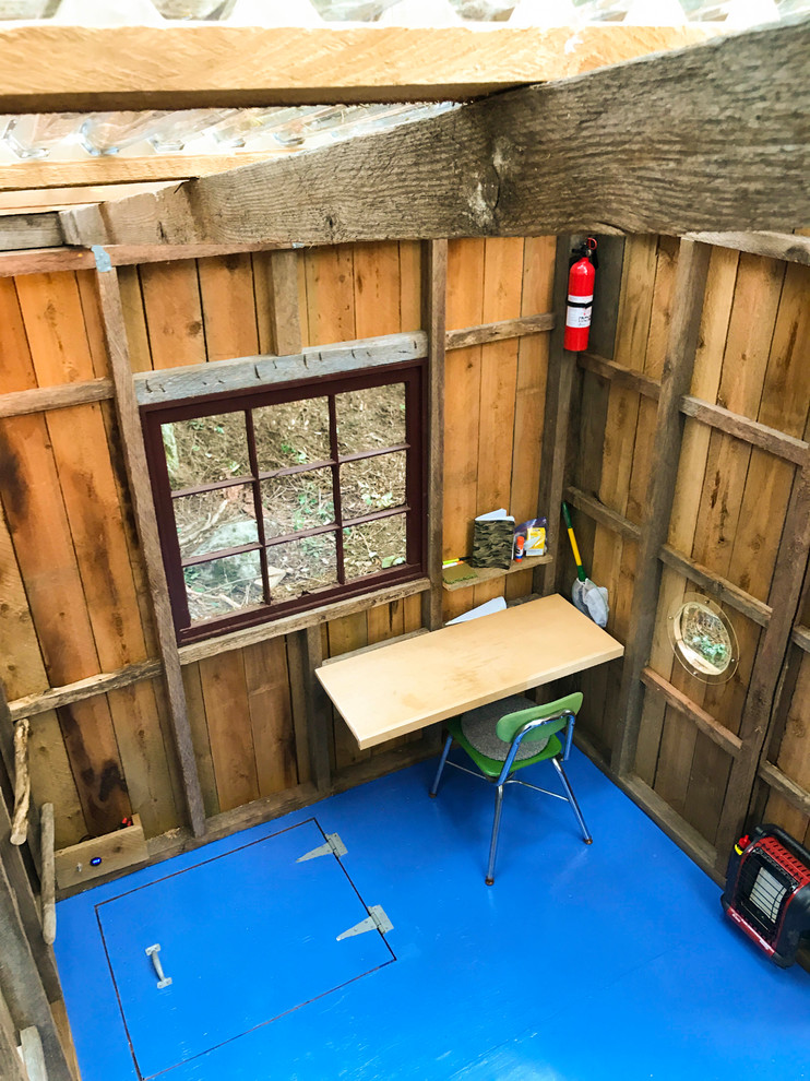 Immagine di una piccola cameretta per bambini da 4 a 10 anni stile rurale con pareti marroni, pavimento in legno verniciato e pavimento blu