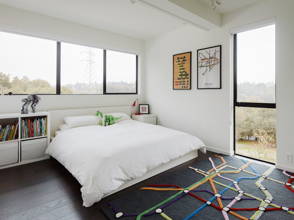 Idéer för funkis pojkrum kombinerat med sovrum, med vita väggar, mörkt trägolv och brunt golv