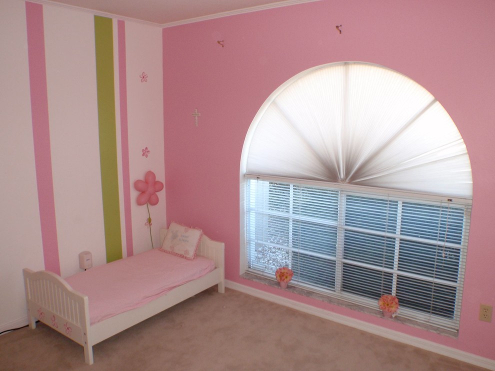 Medium sized classic children’s room for girls in Boston with pink walls and carpet.
