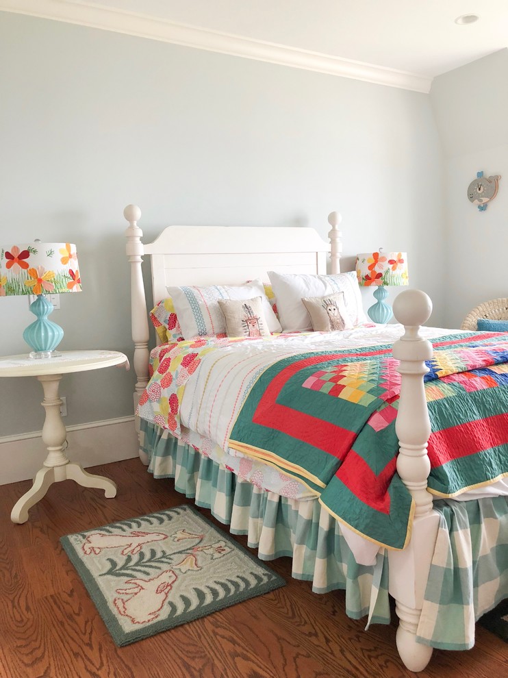 Modelo de dormitorio infantil de 4 a 10 años ecléctico con paredes azules, suelo de madera en tonos medios y suelo marrón