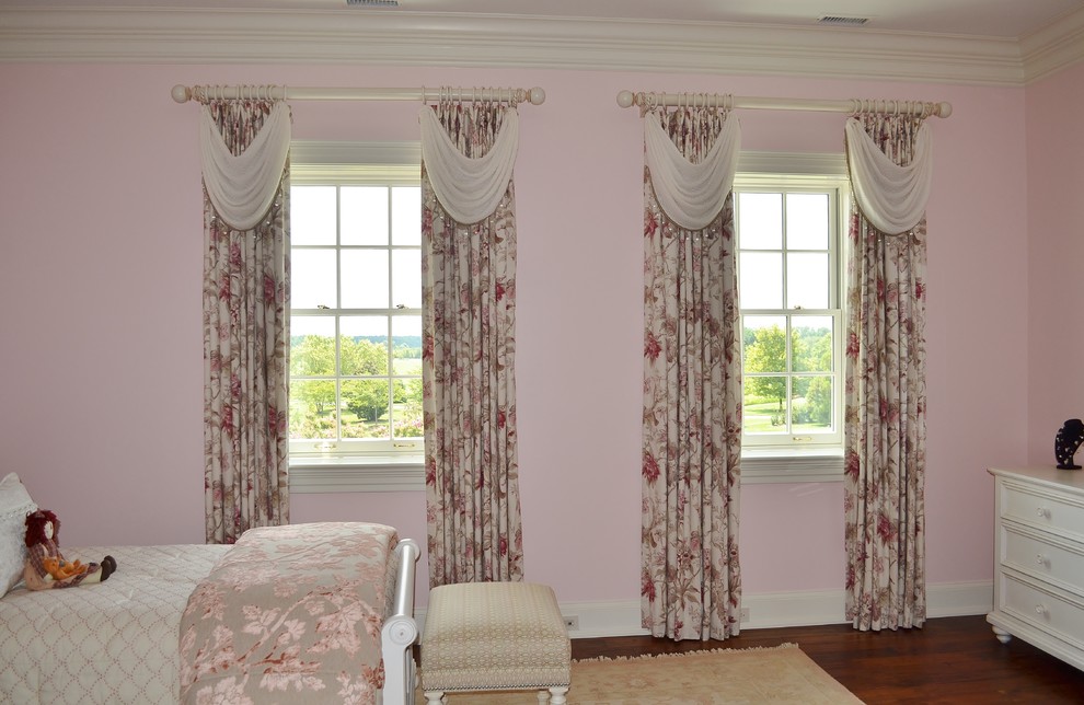 Exempel på ett klassiskt flickrum kombinerat med sovrum, med rosa väggar och mellanmörkt trägolv