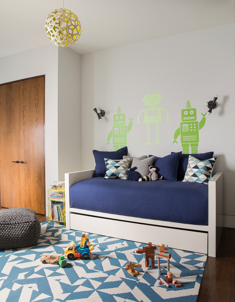 This is an example of a medium sized contemporary children’s room for boys in San Francisco with white walls and medium hardwood flooring.