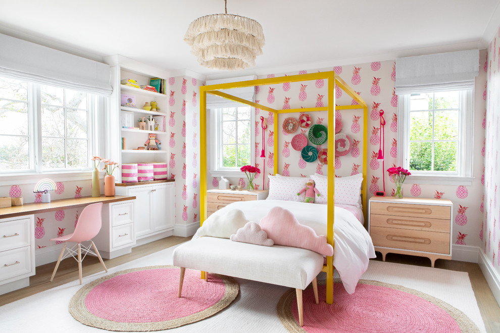 Large classic children’s room for girls in New York with light hardwood flooring, beige floors, pink walls and feature lighting.